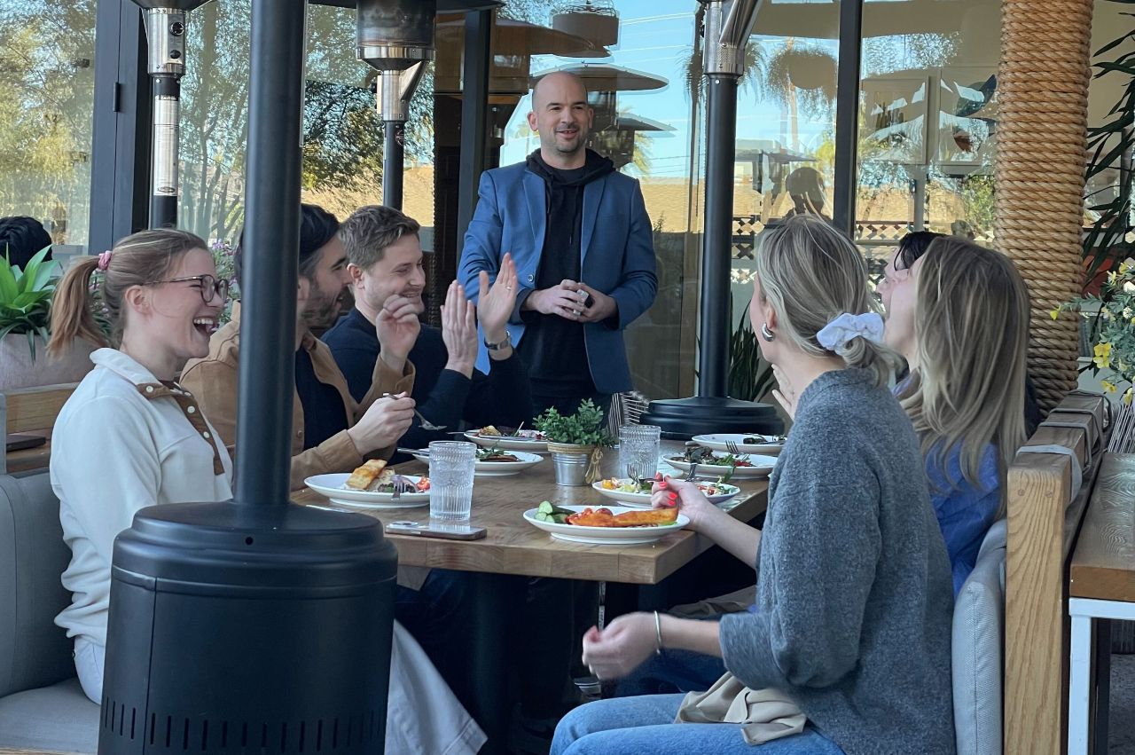 Geo performing close-up magic at a corporate luncheon for a small group of professionals